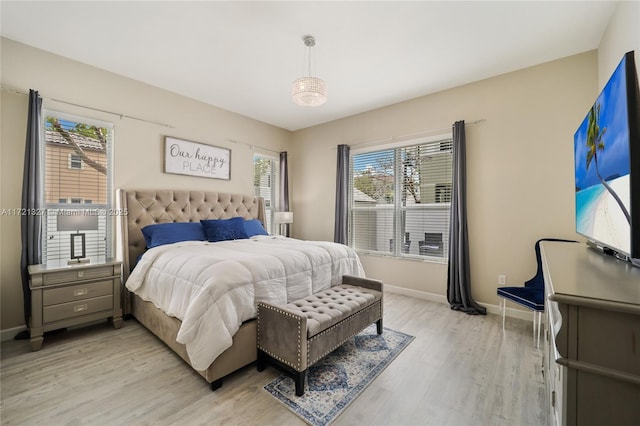 bedroom featuring multiple windows and light hardwood / wood-style flooring