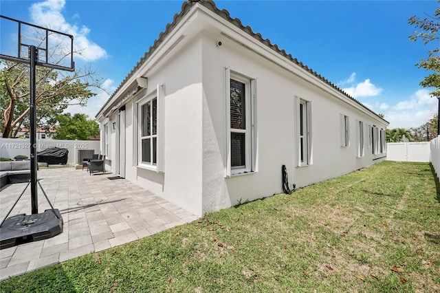 view of property exterior with a yard and a patio