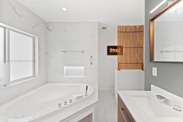 bathroom featuring vanity and a relaxing tiled tub