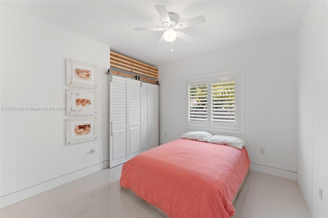 tiled bedroom with ceiling fan and a closet