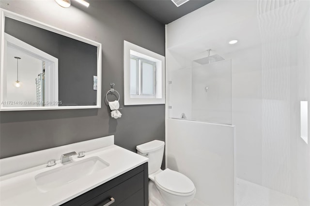 bathroom featuring a shower, vanity, and toilet