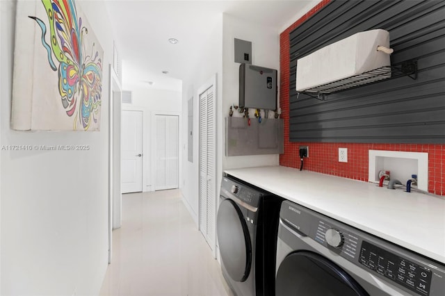 laundry room featuring washing machine and dryer and water heater