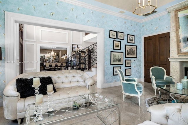 living room with a high end fireplace, ornamental molding, and an inviting chandelier