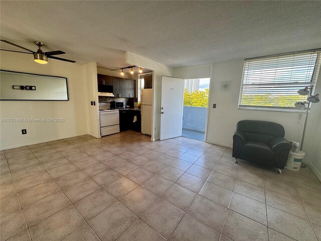 dining room featuring ceiling fan, light tile patterned floors, and a textured ceiling