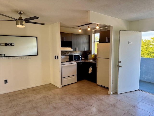 kitchen featuring white appliances, a healthy amount of sunlight, a textured ceiling, and decorative backsplash