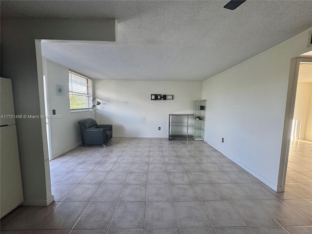 unfurnished living room with baseboards and a textured ceiling