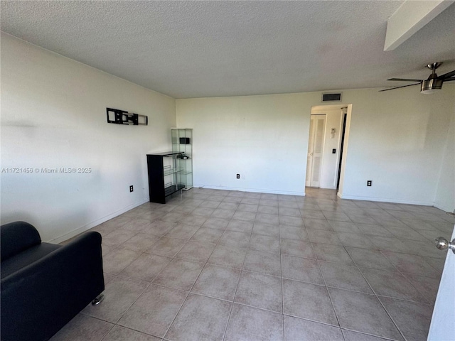 unfurnished living room with ceiling fan, a textured ceiling, visible vents, and baseboards