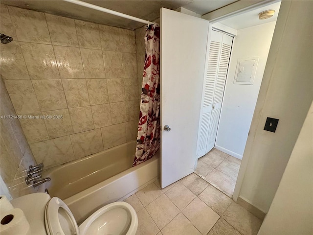 bathroom with a closet, toilet, shower / bath combo with shower curtain, baseboards, and tile patterned floors