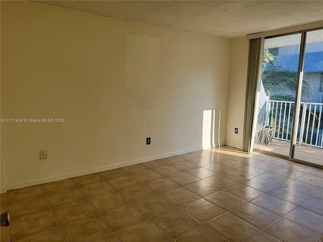 spare room with tile patterned flooring, baseboards, floor to ceiling windows, and a textured ceiling