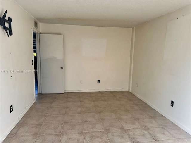 unfurnished room with a textured ceiling, visible vents, and baseboards