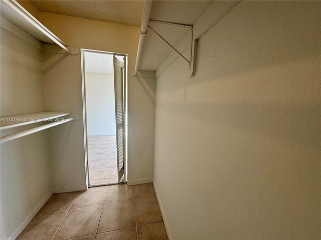 spacious closet with light tile patterned floors