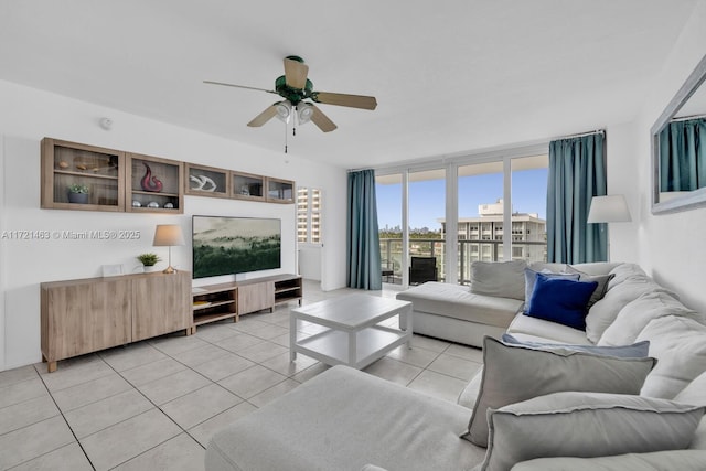 tiled living room with ceiling fan and a wall of windows