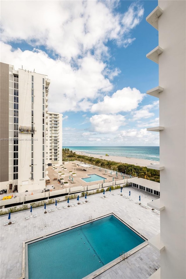 view of swimming pool with a view of the beach and a water view