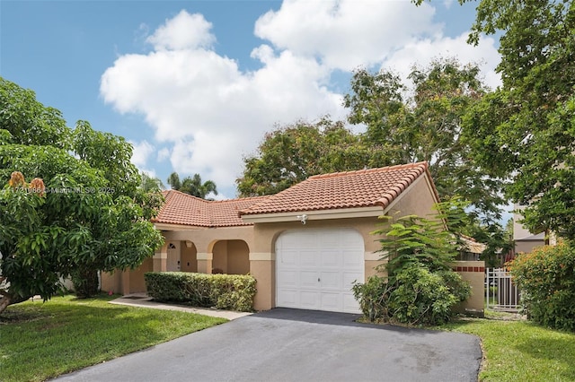 mediterranean / spanish house featuring a garage and a front yard