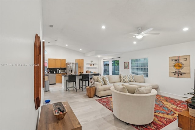 living room with light hardwood / wood-style flooring, vaulted ceiling, and ceiling fan