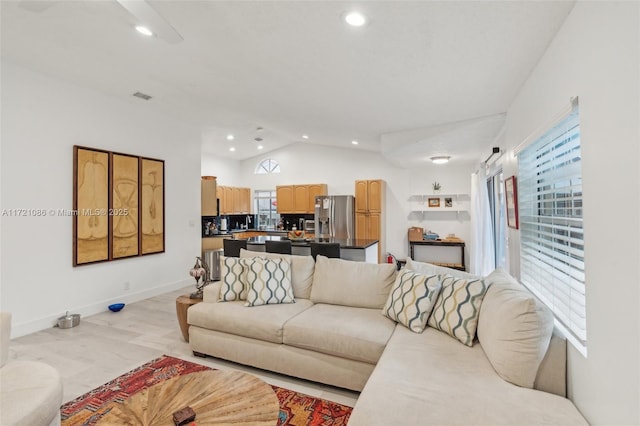 living room with a healthy amount of sunlight and vaulted ceiling