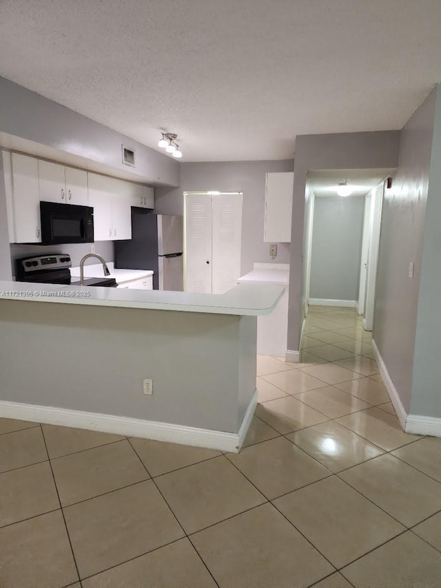 kitchen with light tile patterned floors, stainless steel appliances, a textured ceiling, white cabinets, and kitchen peninsula