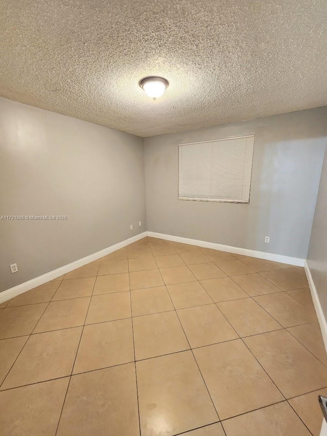 spare room with tile patterned floors and a textured ceiling