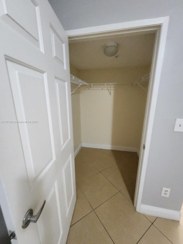 walk in closet with light tile patterned flooring