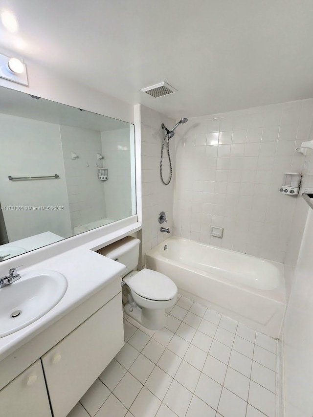 full bathroom with tiled shower / bath, vanity, tile patterned floors, and toilet