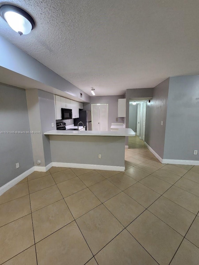 kitchen featuring white cabinets, a textured ceiling, and kitchen peninsula