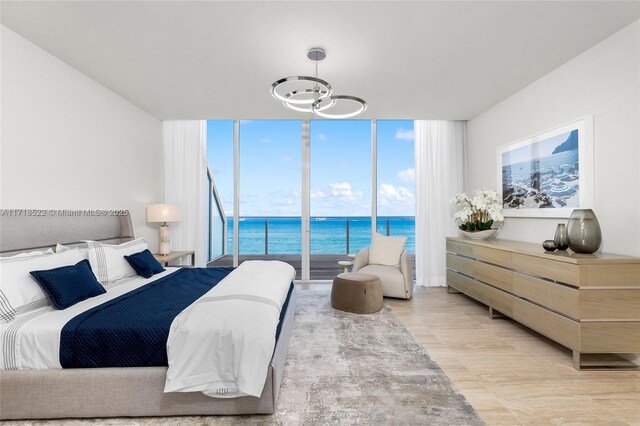 bedroom featuring multiple windows, a water view, and expansive windows