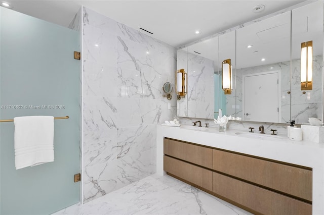 bathroom featuring vanity, a shower with shower door, and tile walls