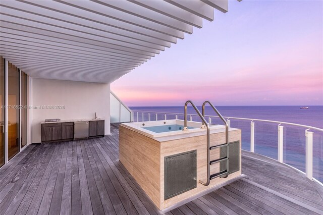 deck at dusk with a water view and sink