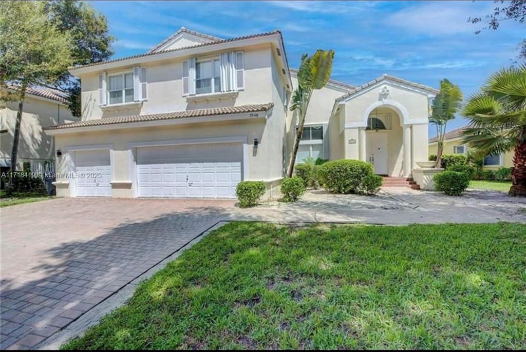 mediterranean / spanish-style house with a garage and a front yard