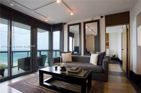 living room featuring a wall of windows, a water view, and a wealth of natural light