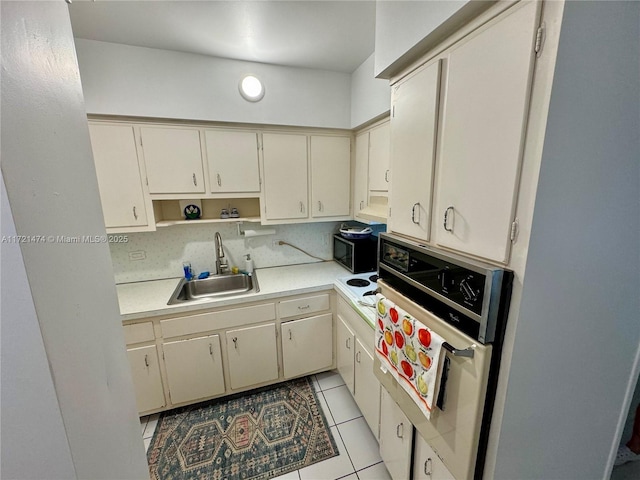 kitchen with sink, light tile patterned floors, tasteful backsplash, cream cabinetry, and wall oven