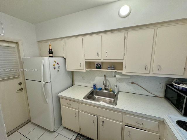 kitchen featuring sink, light tile patterned floors, cream cabinetry, and white refrigerator