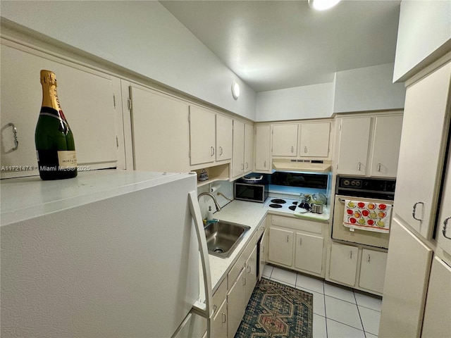 kitchen featuring sink, light tile patterned floors, black appliances, and cream cabinetry