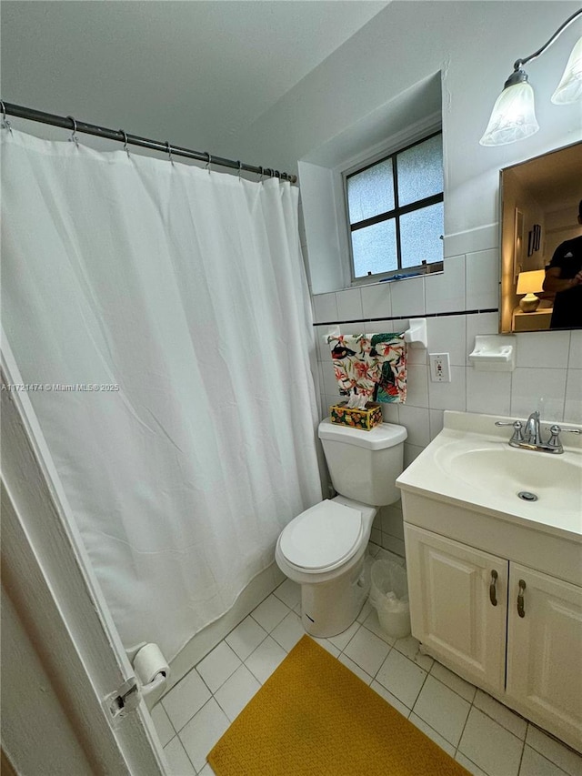 bathroom featuring decorative backsplash, vanity, tile walls, tile patterned flooring, and toilet