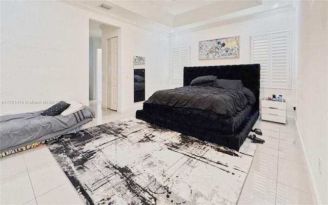 tiled bedroom featuring a tray ceiling