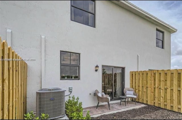 rear view of house featuring a patio area and central AC unit