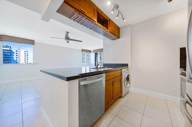 kitchen featuring kitchen peninsula, stainless steel dishwasher, sink, washer / clothes dryer, and plenty of natural light