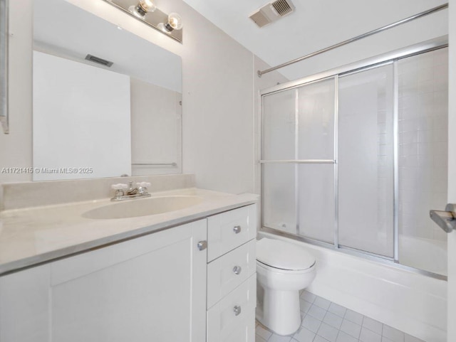 full bathroom featuring combined bath / shower with glass door, tile patterned floors, vanity, and toilet