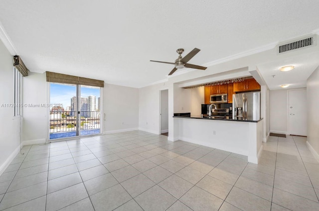 unfurnished living room featuring floor to ceiling windows, light tile patterned floors, ceiling fan, and ornamental molding