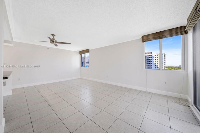 tiled spare room featuring ceiling fan and a textured ceiling