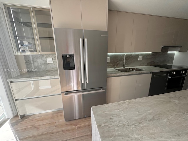 kitchen featuring black appliances, backsplash, and sink