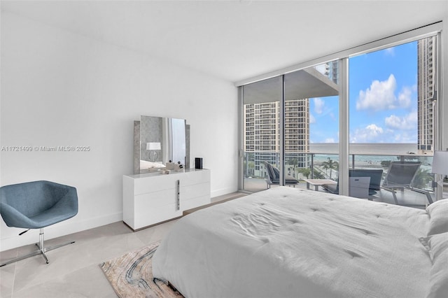 bedroom featuring expansive windows and a water view