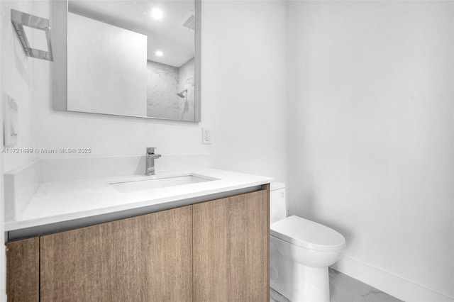 bathroom with vanity, toilet, and a shower