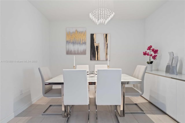 dining space with baseboards and a notable chandelier