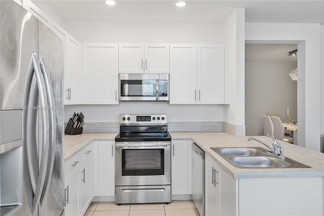 kitchen with stainless steel appliances, light countertops, a sink, and light tile patterned floors