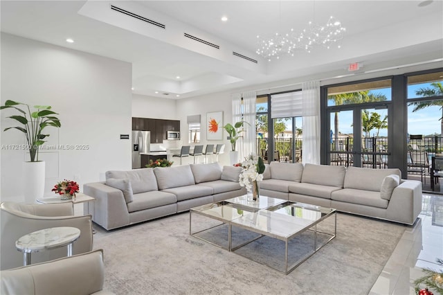 tiled living room with a tray ceiling, french doors, visible vents, and recessed lighting