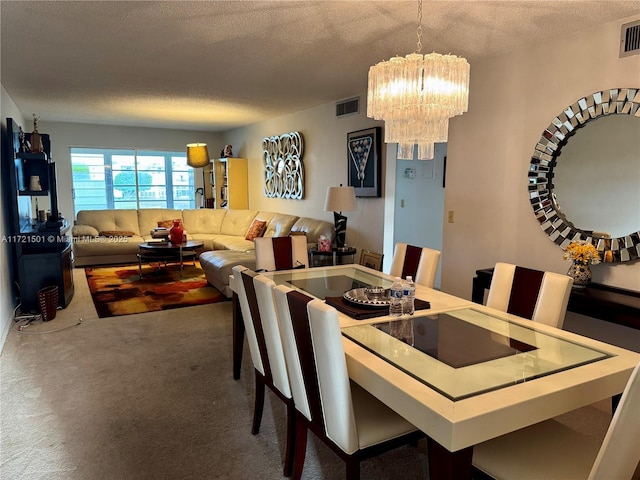 carpeted dining room with a textured ceiling and a notable chandelier