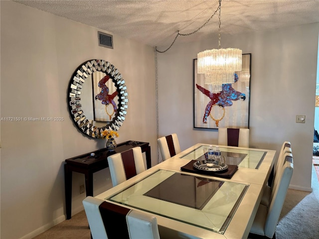 dining room featuring carpet floors, a textured ceiling, and a notable chandelier