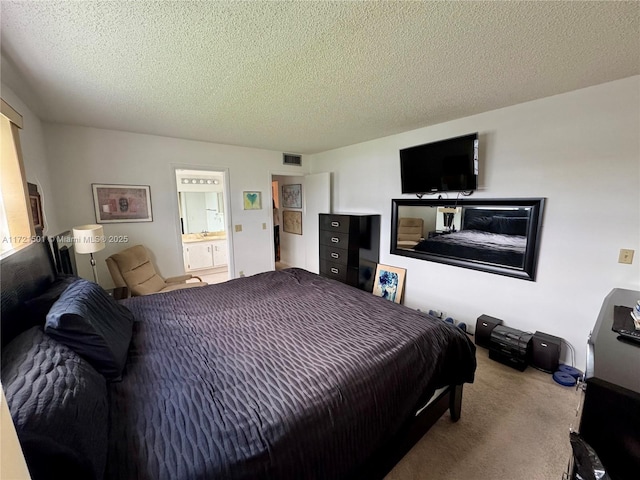 carpeted bedroom featuring connected bathroom and a textured ceiling