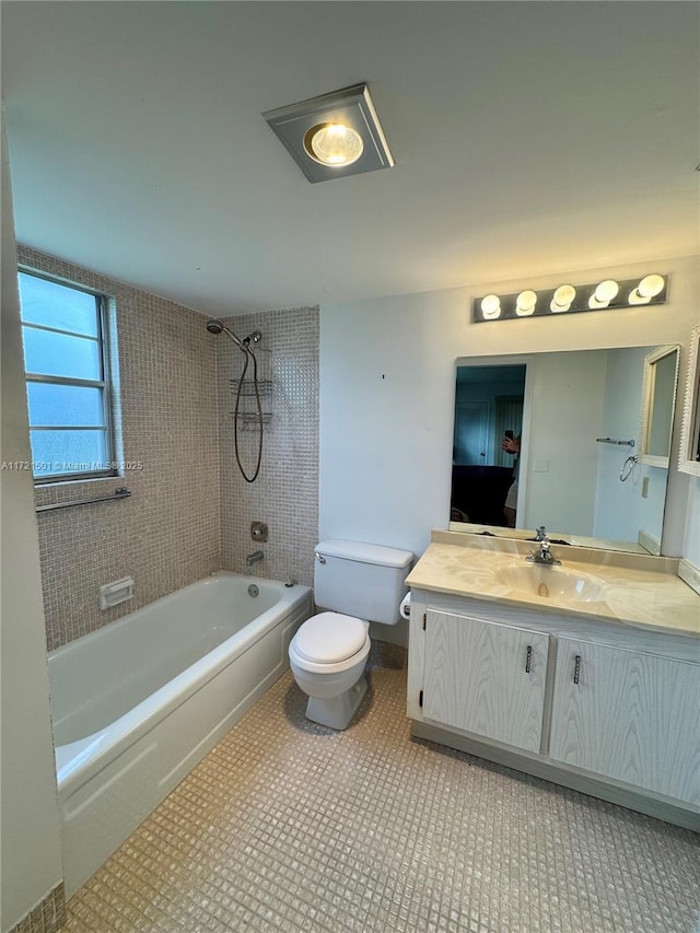 full bathroom featuring tile patterned floors, tiled shower / bath combo, toilet, and vanity